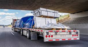 A flatbed semi-trailer being loaded with cargo, representing the logistics industry.